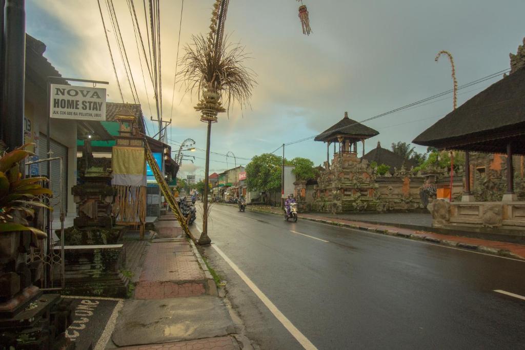 a street in a town with a motorcycle on the road at Nova Homestay Ubud in Ubud