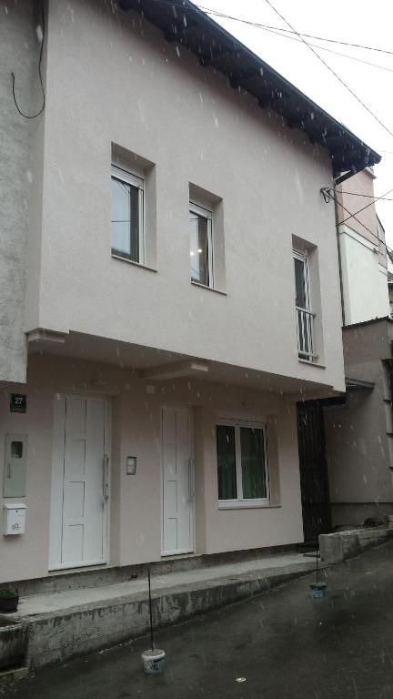 a white house with two white garage doors at APARTMANI VIJEĆNICA in Sarajevo