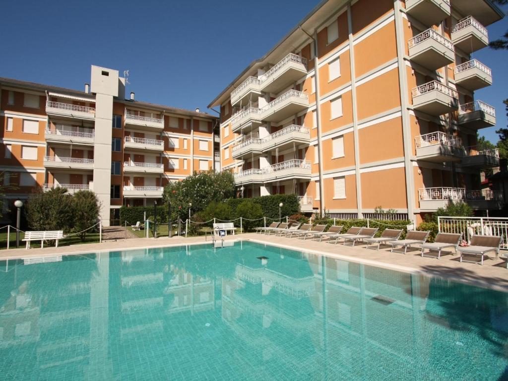a large swimming pool in front of a building at Residenza Gardenia in Lignano Sabbiadoro