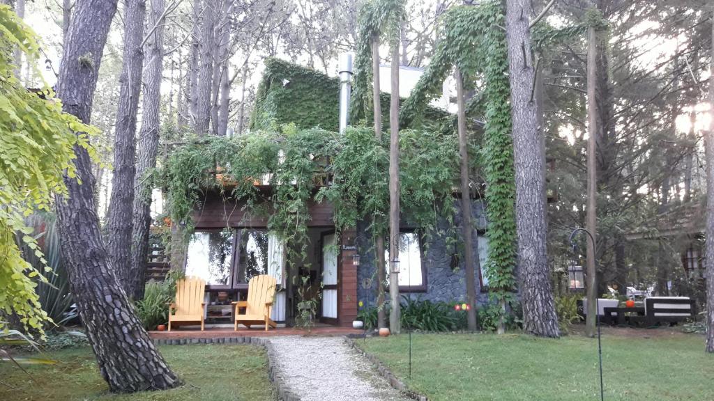 una casa con mesa y sillas en el patio en La Hora del Sol Apart en Mar de las Pampas