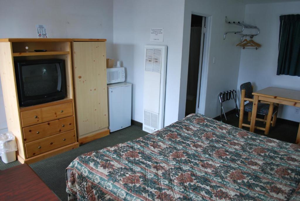 a hotel room with a bed and a television at Plaza Inn in Great Falls