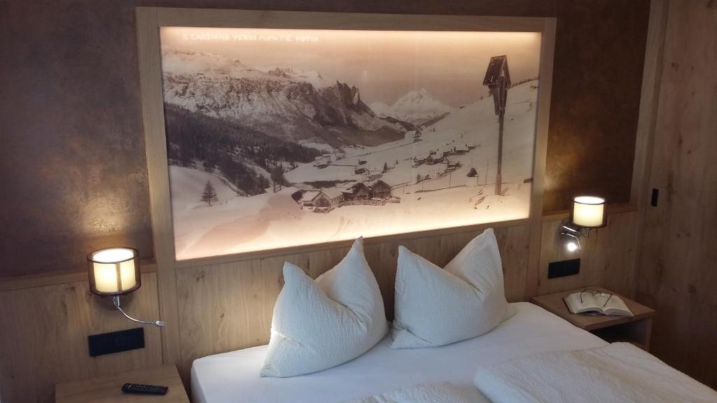 圣卡夏诺App. Villa Fraina的一间卧室配有一张带白色枕头的床和一幅画