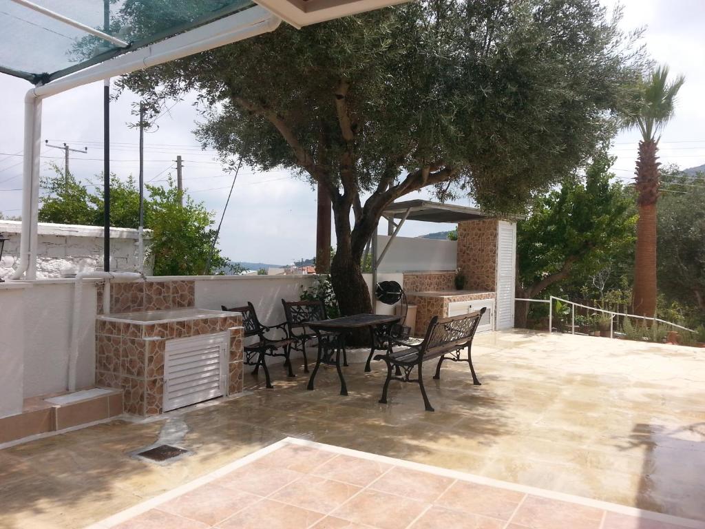 un patio con sillas, una mesa y un árbol en Kanarinis Apartments, en Omodos