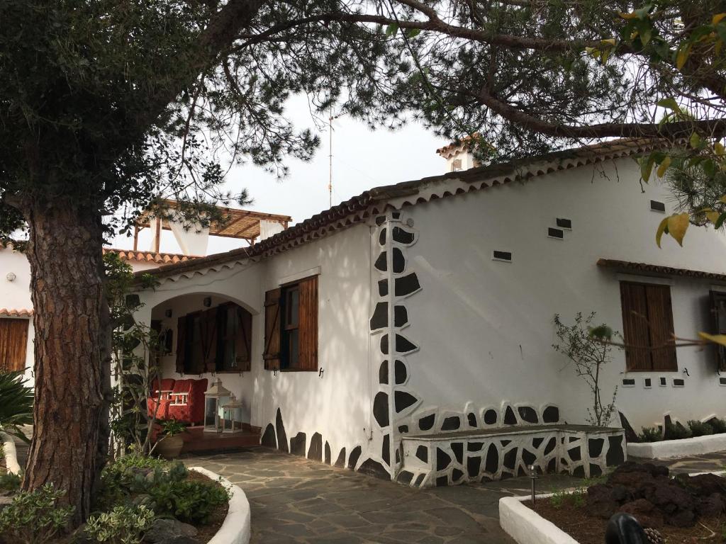 Una casa blanca con un árbol delante. en La Casita de Las Palmas VV, en Las Palmas de Gran Canaria