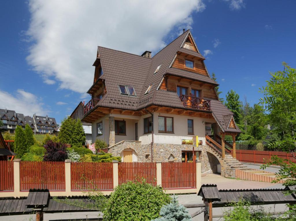 a large house with a gambrel roof at Pokoje Gościnne Pod Giewontem in Zakopane