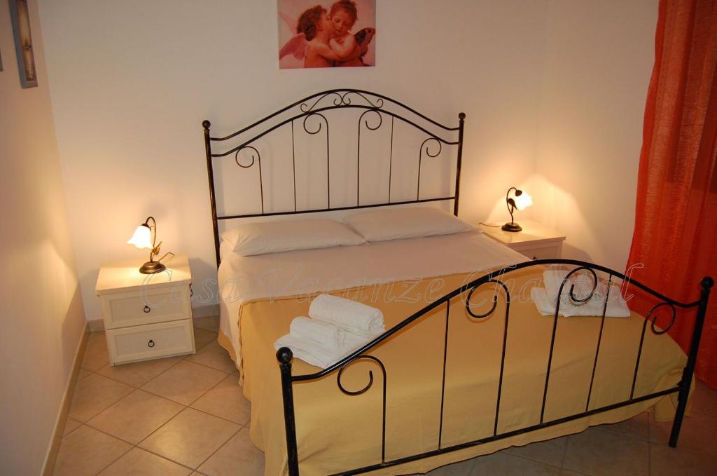 a bedroom with a bed with two night stands and two lamps at Appartamento con Giardino - WIFI in San Vito lo Capo