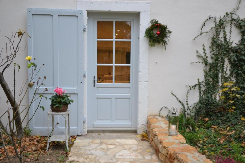 una puerta de una casa blanca con flores en una mesa en Sur la colline, en Lyon