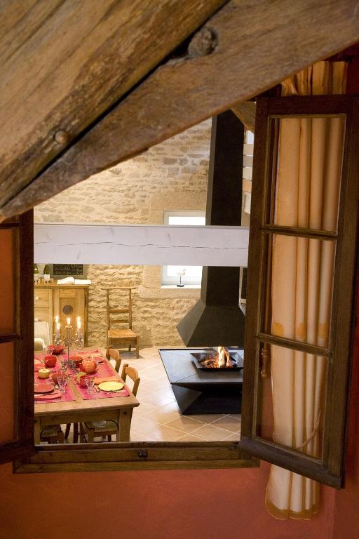 un salon avec une table et une cheminée dans l'établissement Gite Le Meix Chapeau, à Levernois