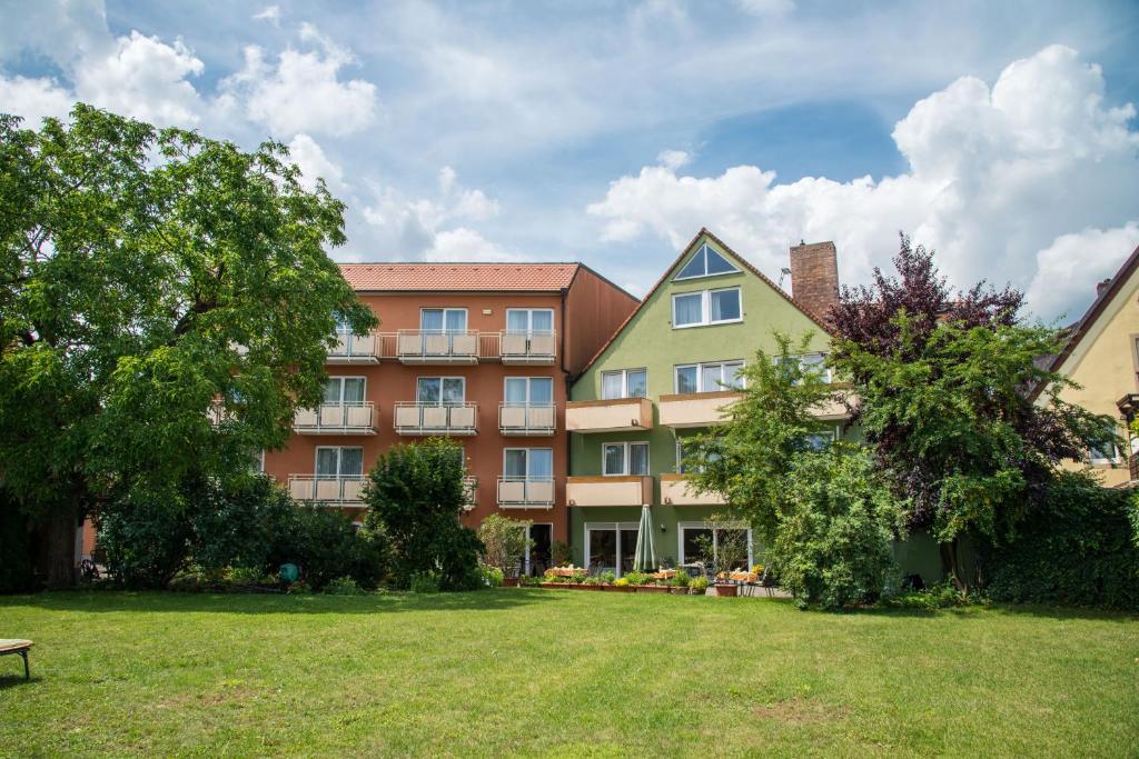 a large building with a park in front of it at Weinhotel Rose in Volkach