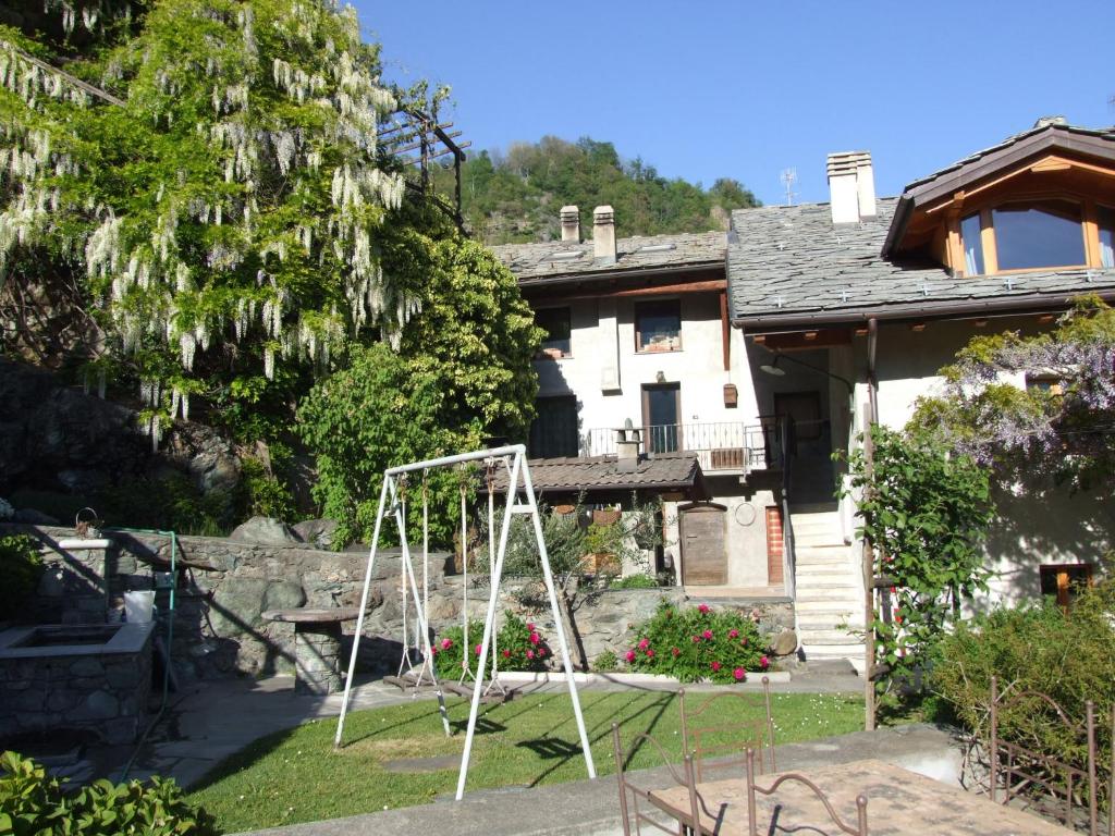 eine weiße Schaukel im Hof eines Hauses in der Unterkunft Le Rocher in Châtillon