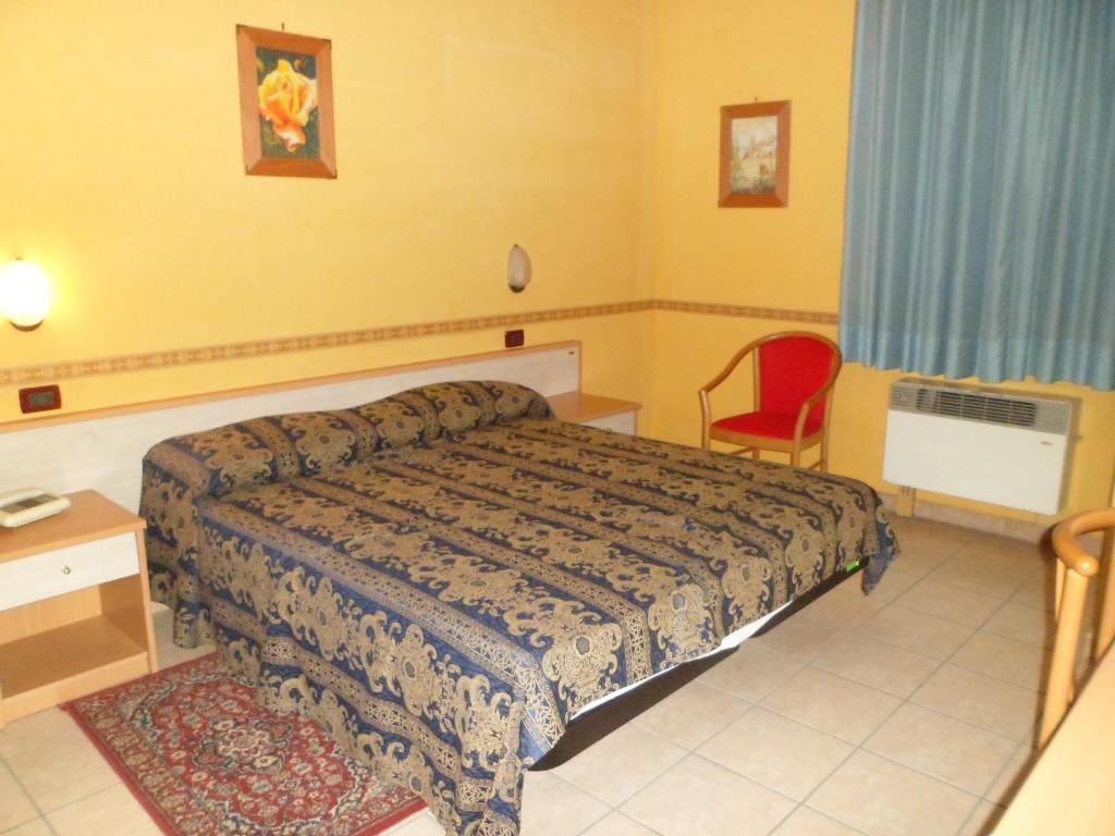 - une chambre avec un lit et une chaise rouge dans l'établissement Motel Tempio, à Polla