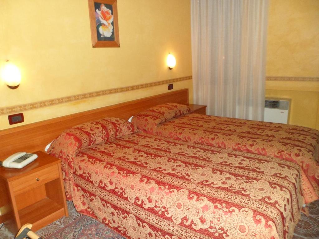 A bed or beds in a room at Motel Tempio