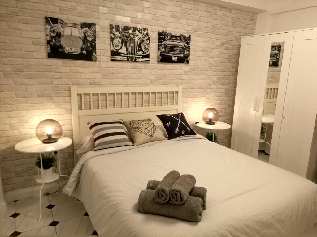 - une chambre avec un grand lit et des serviettes dans l'établissement Apartamento Capuchinos, à Malaga