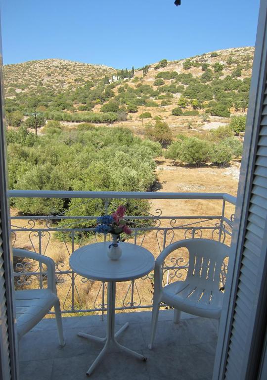 a table and two chairs on a balcony with a view at Sandalis Hotel in Pythagoreio