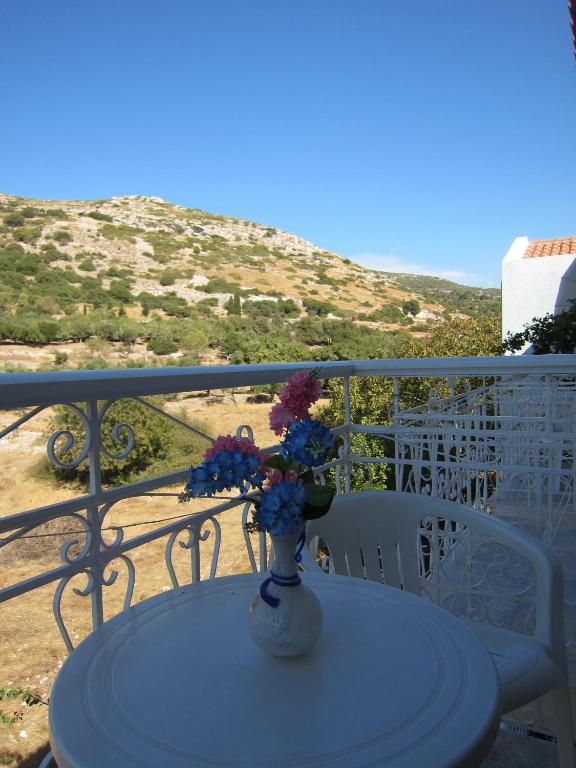 a vase with flowers sitting on a table on a balcony at Sandalis Hotel in Pythagoreio
