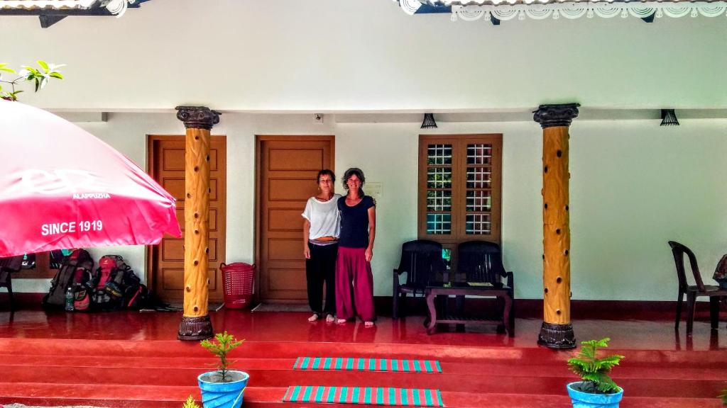 マラリクラムにあるMarari Nadiyaの二人の女が家の階段に立っている