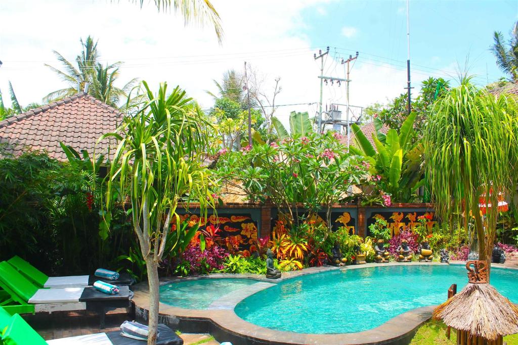 a swimming pool in a garden with trees and flowers at L'Bulu Menjangan in Banyuwedang