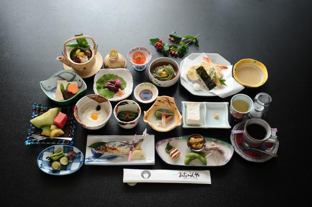 um grupo de pratos de alimentos sobre uma mesa em Atarashiya Ryokan em Tenkawa