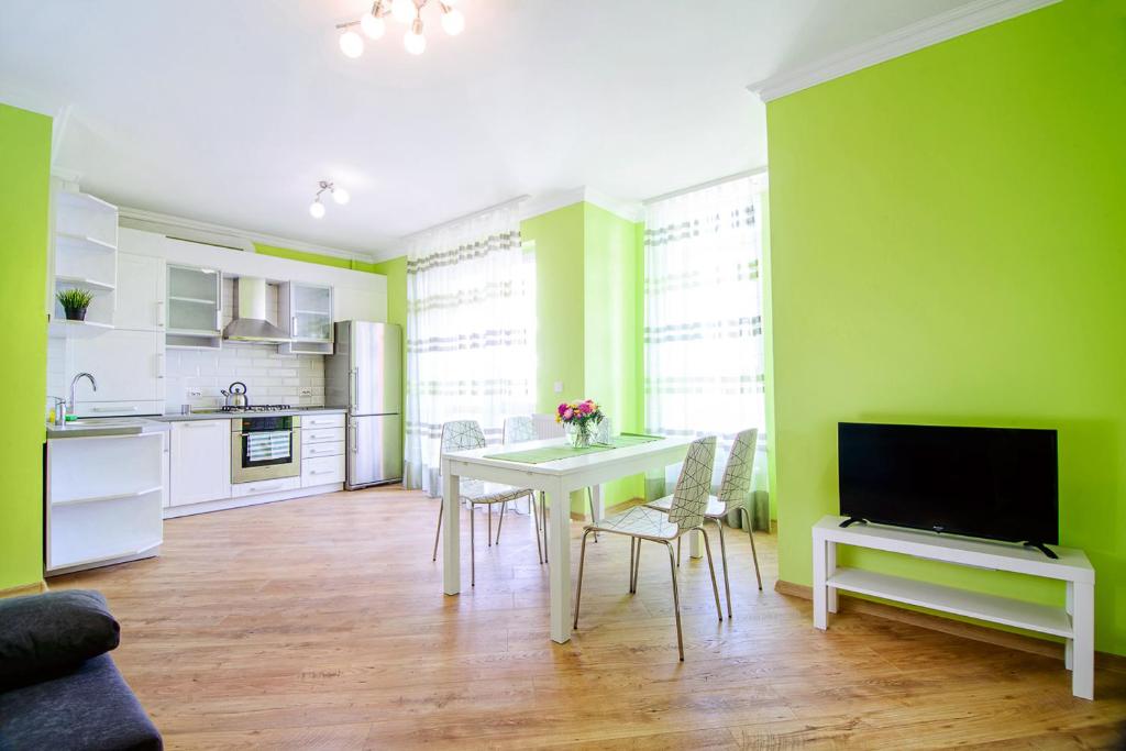 リヴィウにあるModern apartment in 10 min from city centerのリビングルーム(テーブル付)、緑の壁のキッチン