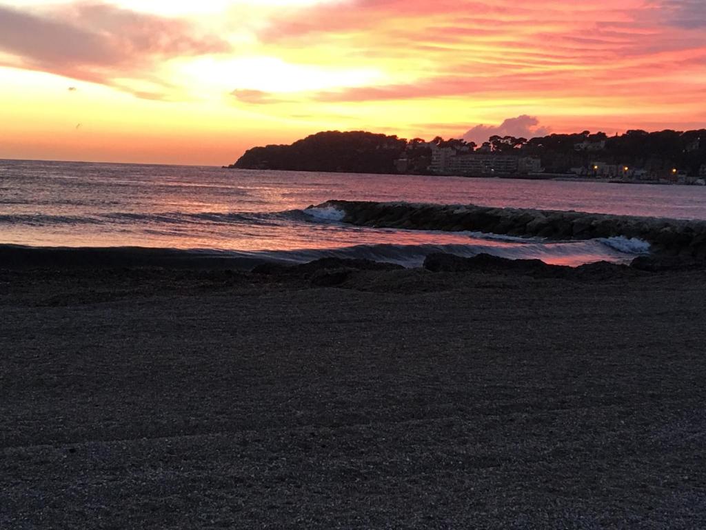 a sunset on a beach with the ocean at Les Lones avec jardin in Six-Fours-les-Plages