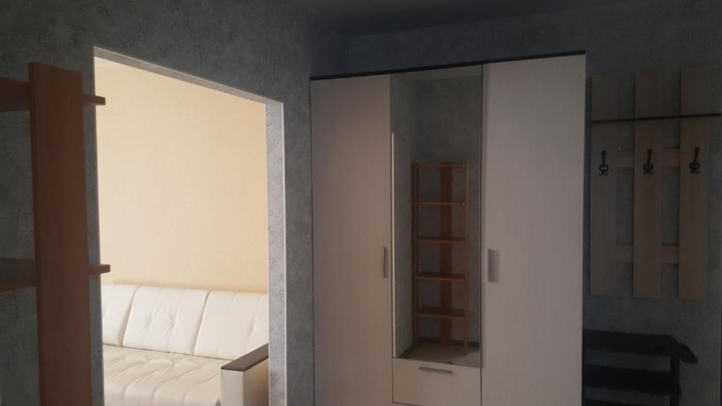 ゲレンジークにあるApartments on Gornayaの鏡と白いソファ付きの部屋