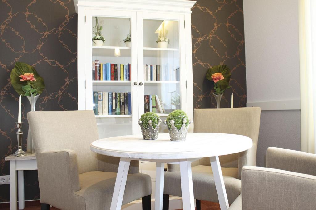ein Esszimmer mit einem weißen Tisch und Stühlen in der Unterkunft Gästehaus Schmidt in Bad Lippspringe