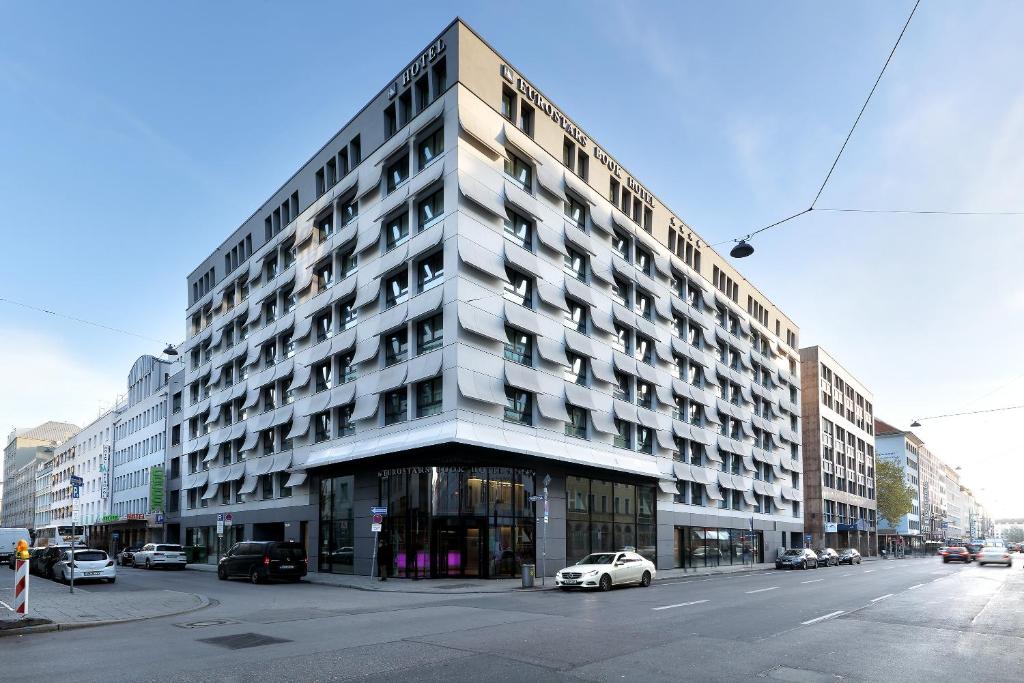 a large building with cars parked in front of it at Eurostars Book Hotel in Munich