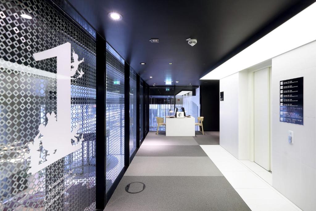 a hallway of an office with a wall of glass at Eurostars Book Hotel in Munich