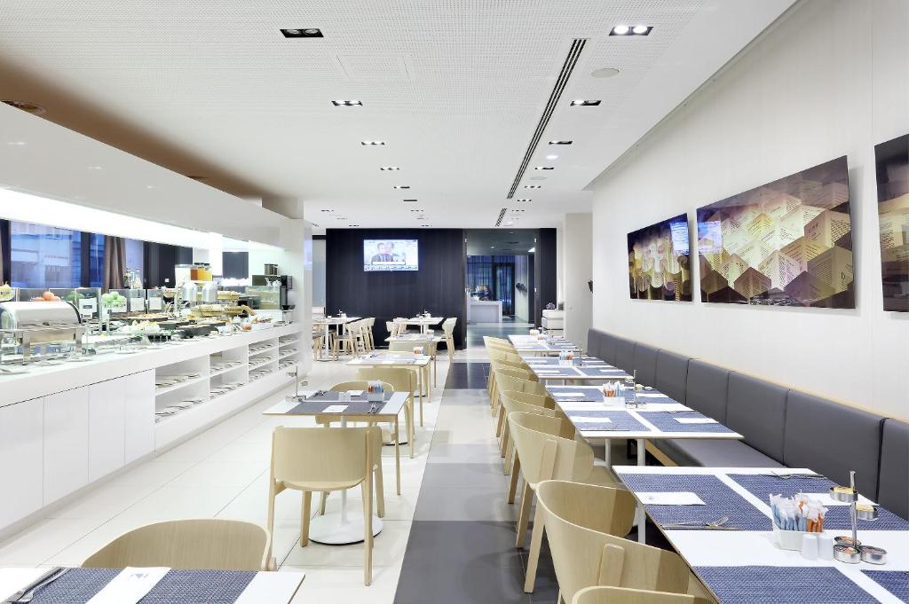 a restaurant with tables and chairs and a counter at Eurostars Book Hotel in Munich