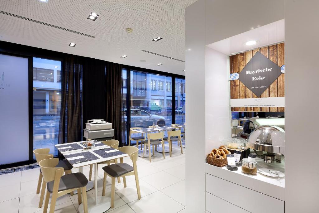 a dining room with tables and chairs in a restaurant at Eurostars Book Hotel in Munich