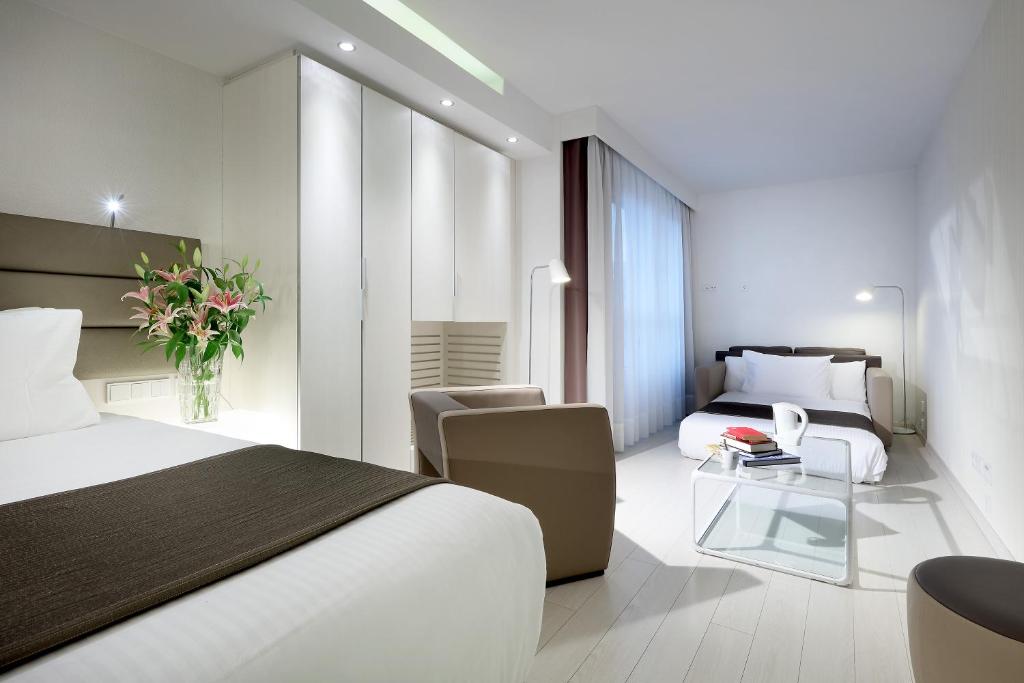 a hotel room with a bed and a living room at Eurostars Book Hotel in Munich