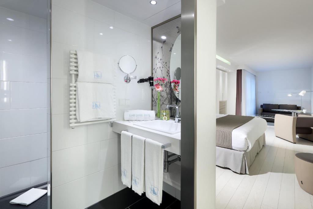 a bathroom with a sink and a bed in a room at Eurostars Book Hotel in Munich