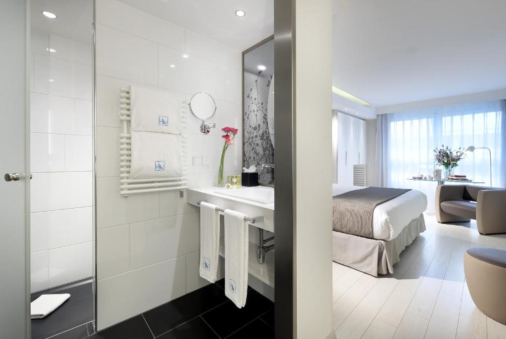 a hotel room with a bed and a bathroom at Eurostars Book Hotel in Munich
