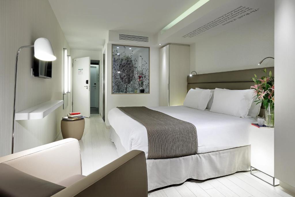 a hotel room with a large white bed in it at Eurostars Book Hotel in Munich