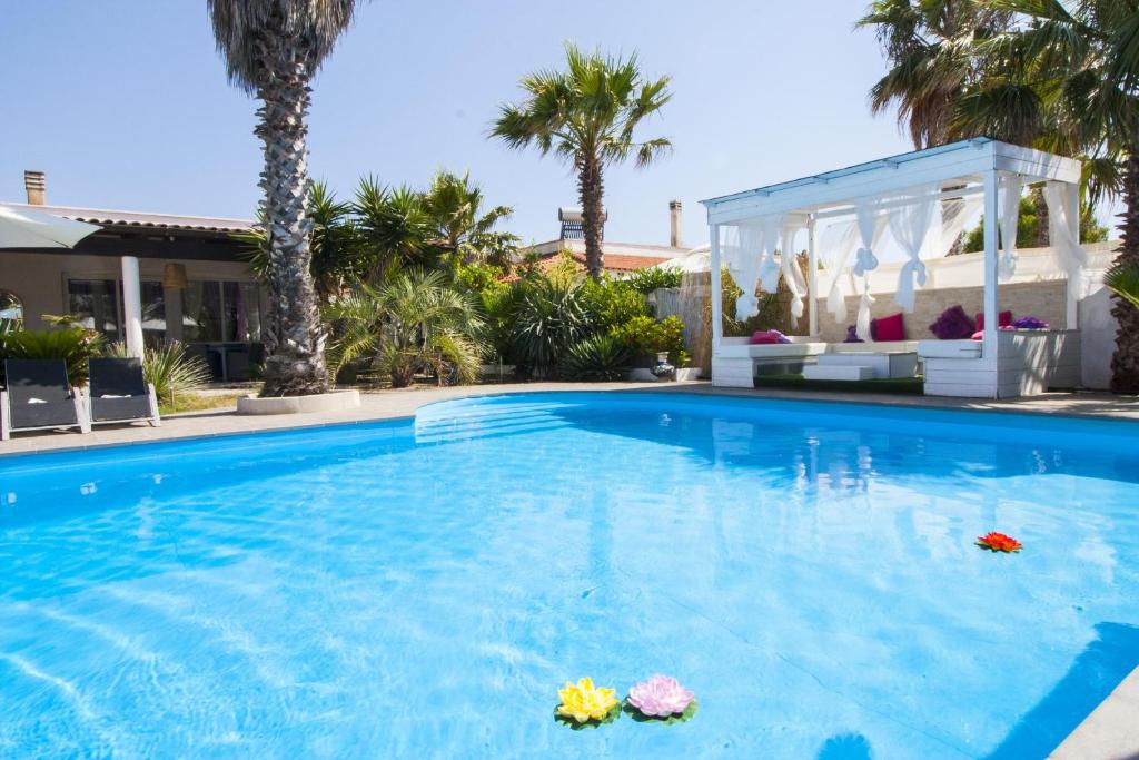 a swimming pool in a house with palm trees at tenuta cotriero in Marina di Mancaversa