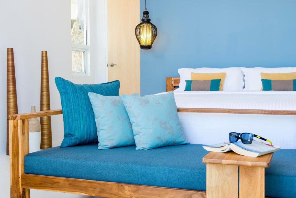 a bedroom with a bed with blue pillows at Krabi Home Resort in Tab Kaek Beach