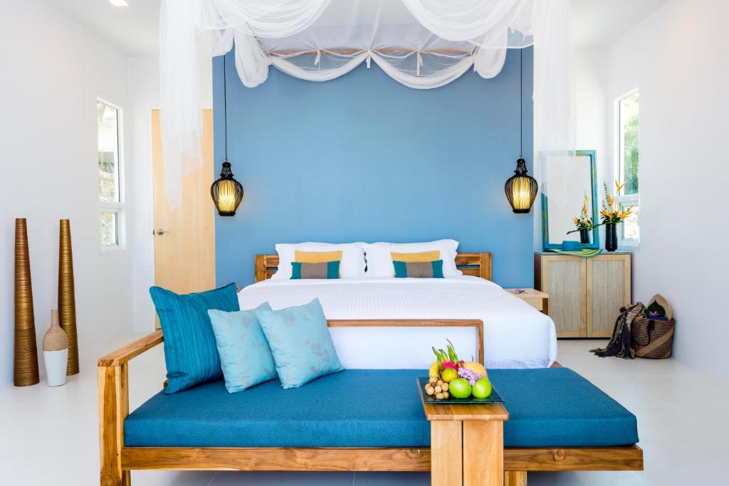 1 dormitorio con cama y pared azul en Krabi Home Resort, en Tab Kaek