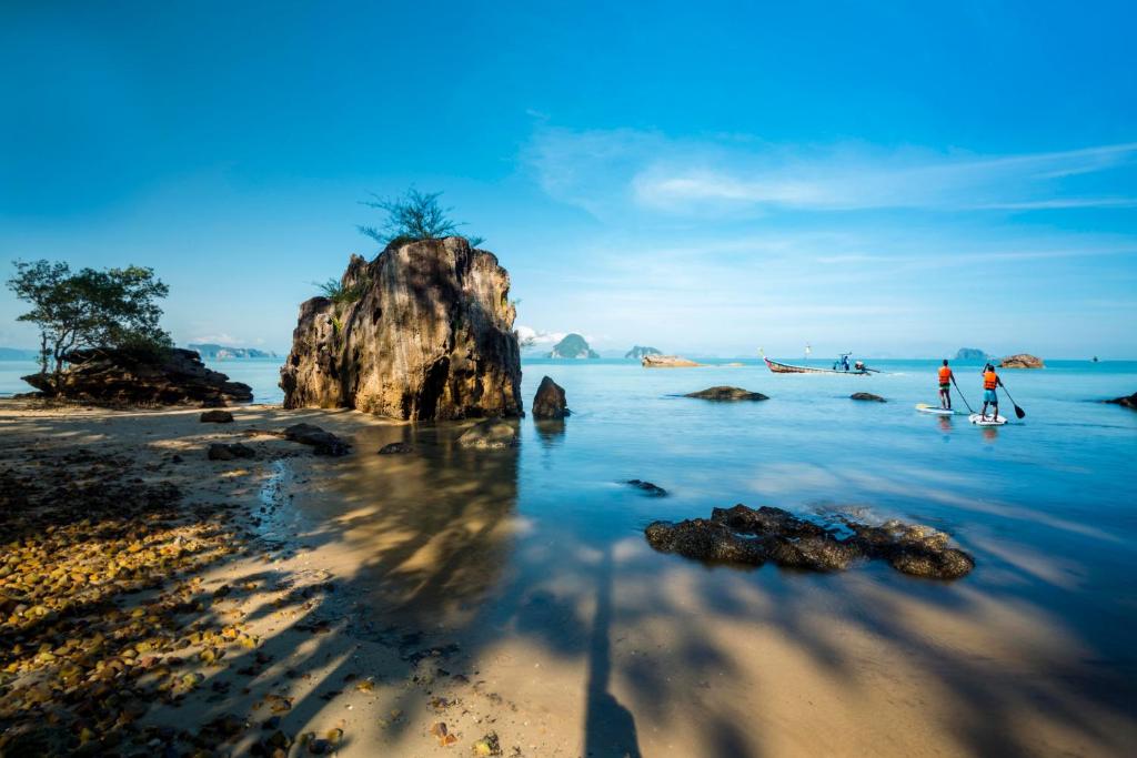 two people standing in the water at the beach at Krabi Home Resort in Tab Kaek Beach