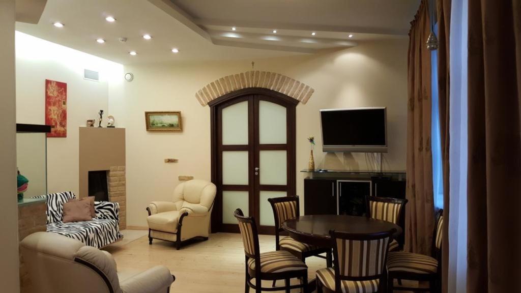 - un salon avec une table et des chaises dans l'établissement Asmenos apartamentai, à Vilnius