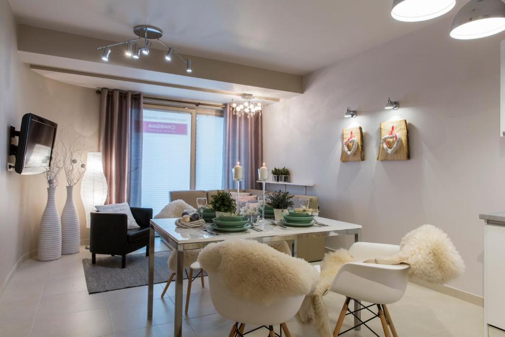 a dining room and living room with a table and chairs at Apartament Charisma in Zakopane