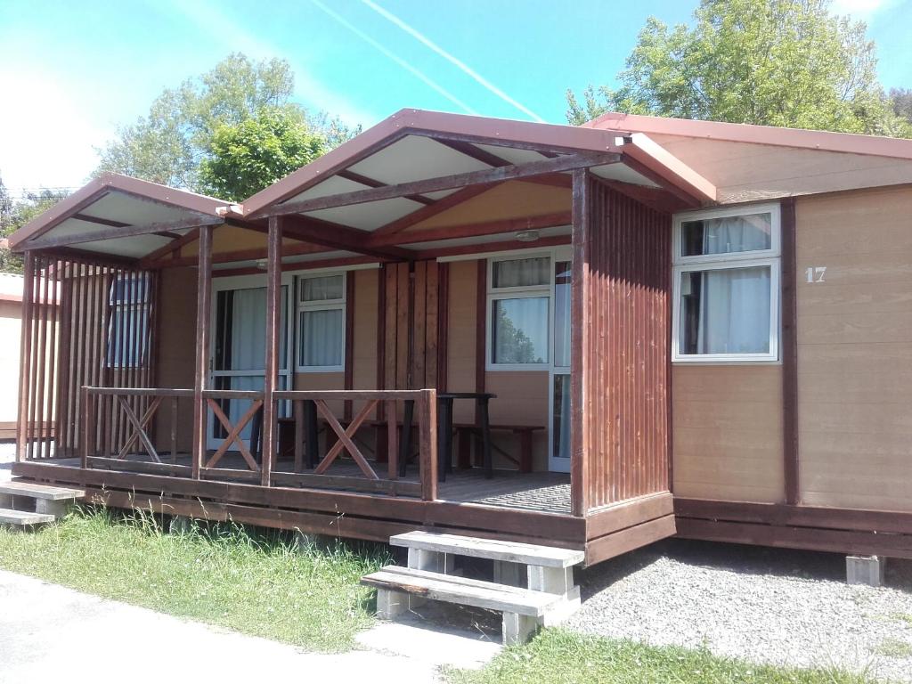 eine kleine Hütte mit einer Veranda und einer Terrasse in der Unterkunft Camping Deva in Deva