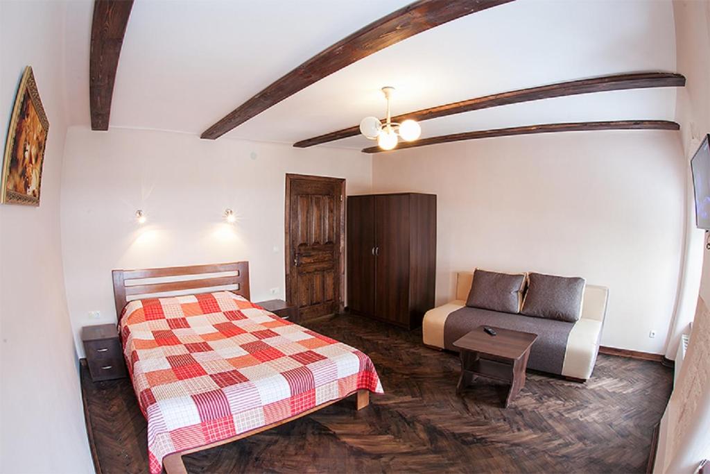 a bedroom with a bed and a couch in a room at Квартира в центрі по вулиці Вірменська 12 дві спальні з двуспальними ліжками є інтернет сама Площа Ринок in Lviv