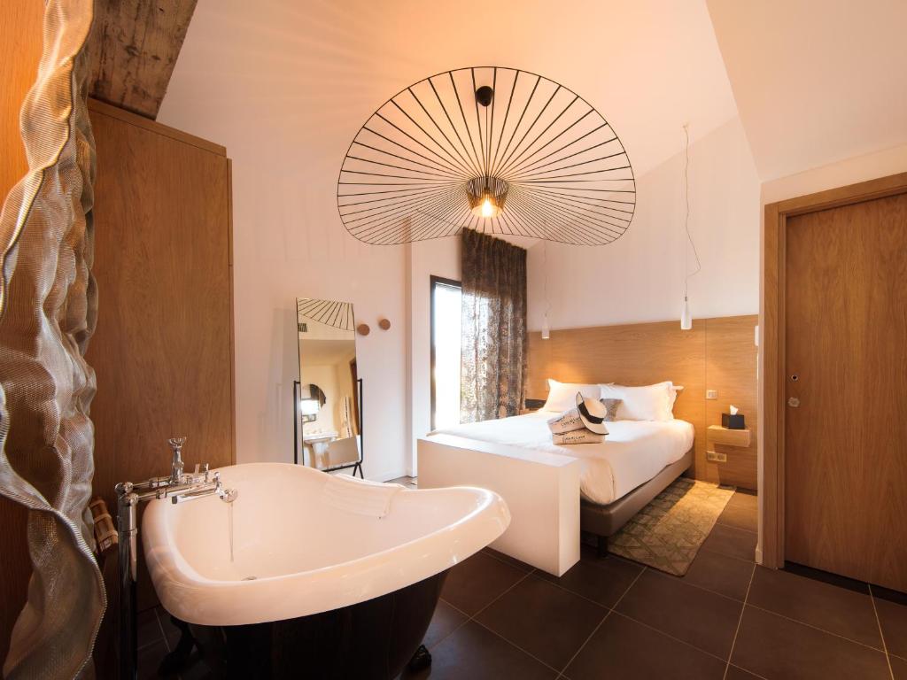 a bathroom with a bed and a tub and a sink at Citta di Lume Suites &amp; Lofts in Porto-Vecchio