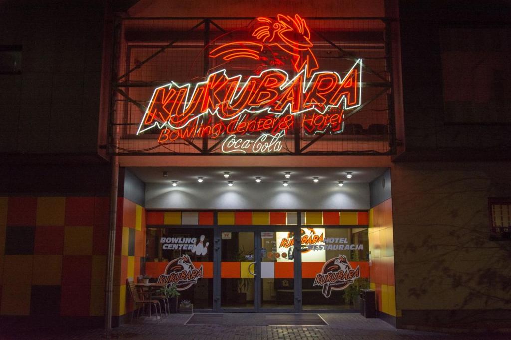 a neon sign on the front of a restaurant at Kukubara Bowling Center in Myszków