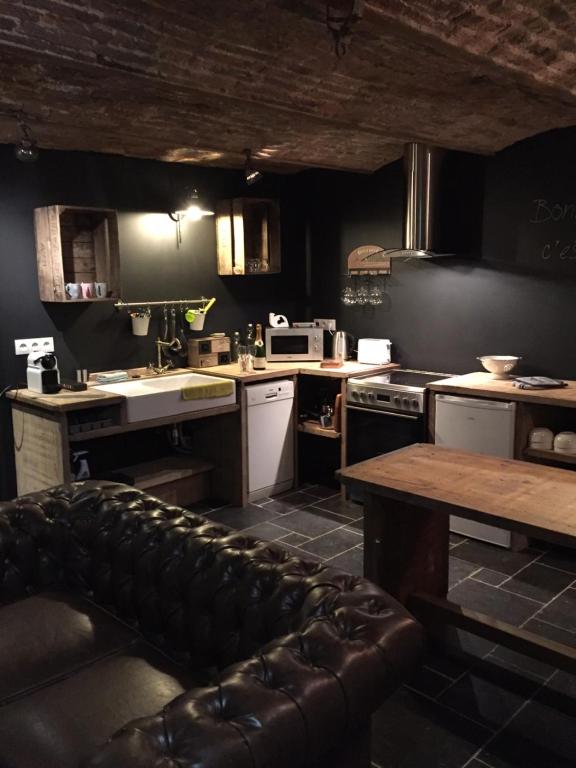 a kitchen with a couch in the middle of it at Gîte de Corbion Loft1 in Ciney