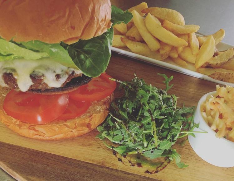 um hambúrguer e batatas fritas numa tábua de cortar com uma sanduíche e uma salada em The Lord Nelson em Sutton on Trent