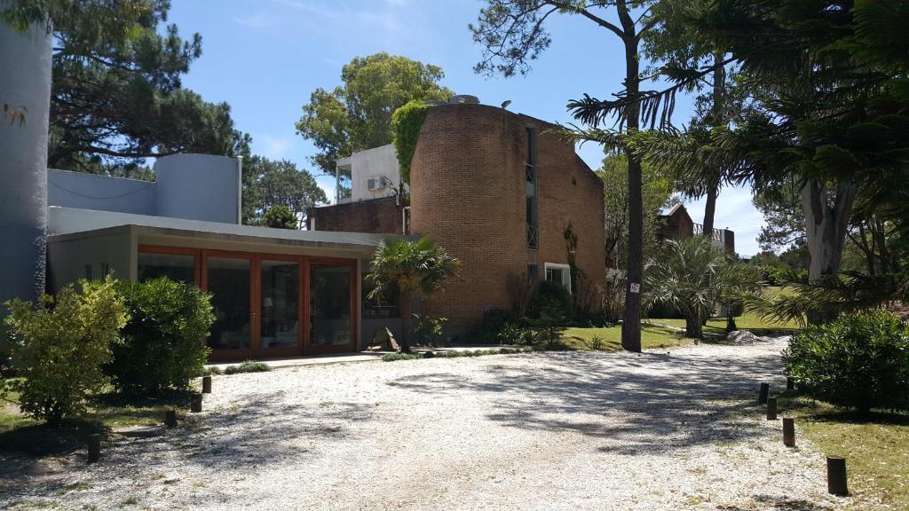 an exterior view of a house with a brick building at Hotel Club de La Barra in Punta del Este