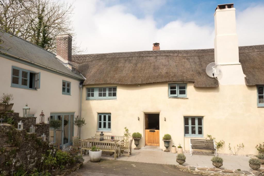 a large white house with a thatched roof at Glebe Farm B&B in Kingsbridge