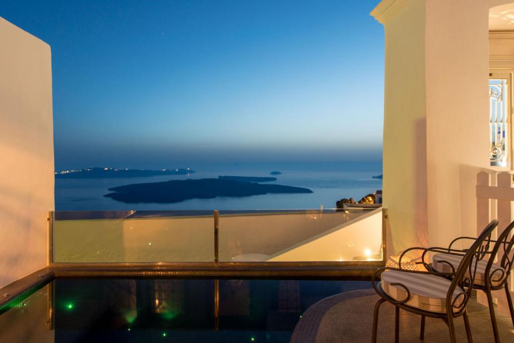 a balcony with chairs and a view of the ocean at Senses Suites in Imerovigli