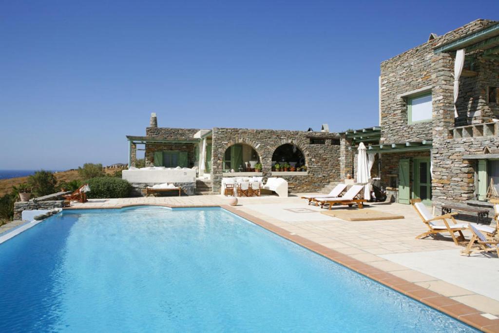 a swimming pool in front of a house at Villa Juno in Kea in Koundouros